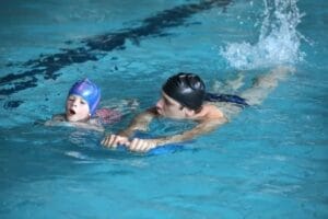 Antrenor ghidând un cursant în timpul unui exercițiu cu pluta