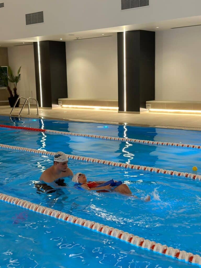 Antrenor asistând un cursant în timpul unui exercițiu de plutire