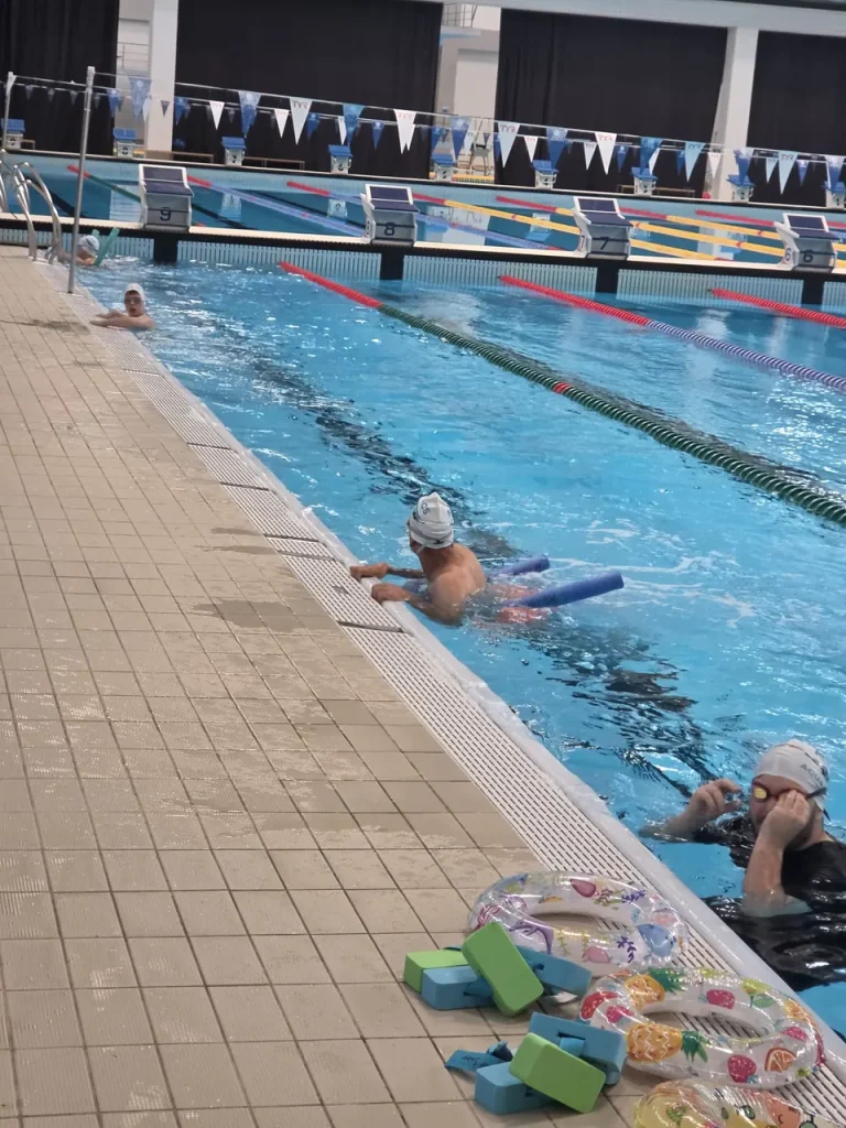 Activitate de înot ghidată de antrenor lângă marginea bazinului Otopeni