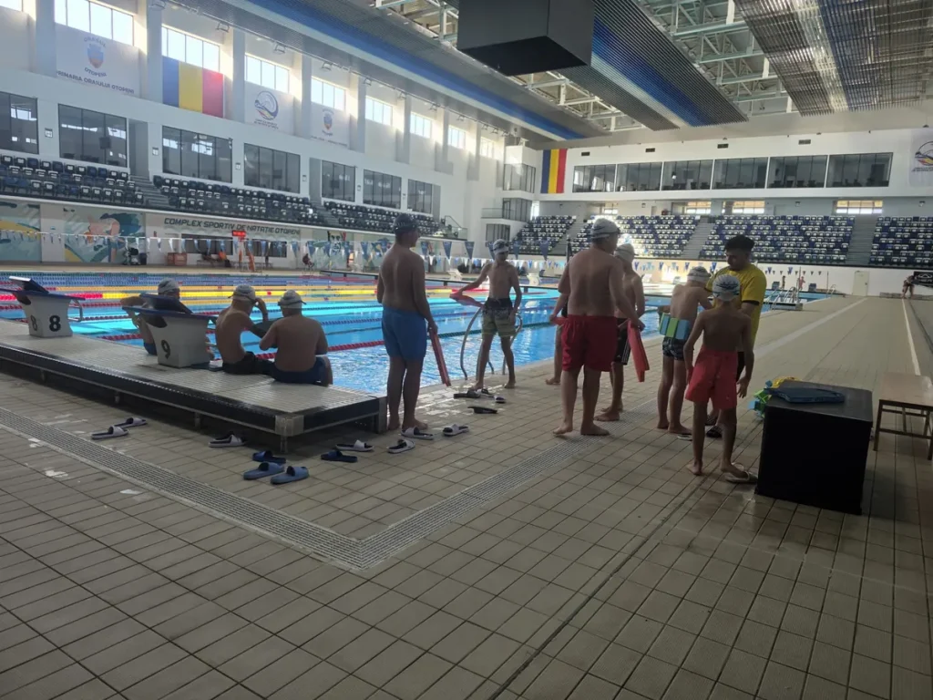 Copii și antrenori la începutul unei activități de înot în Otopeni