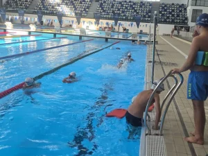 Copii care exersează în bazin, sub îndrumarea antrenorului Aqua Swim